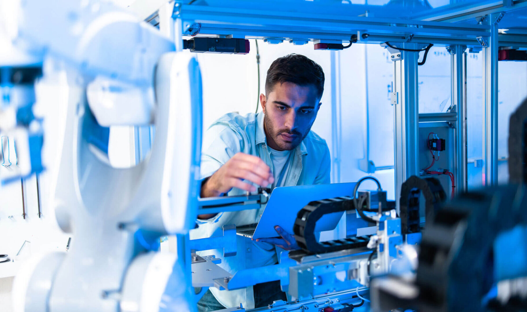 GettyImages-1310750664-copy A man working on an assembly machine.