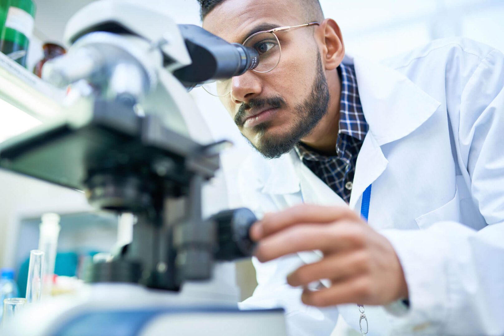 A man looking through a microscope at something