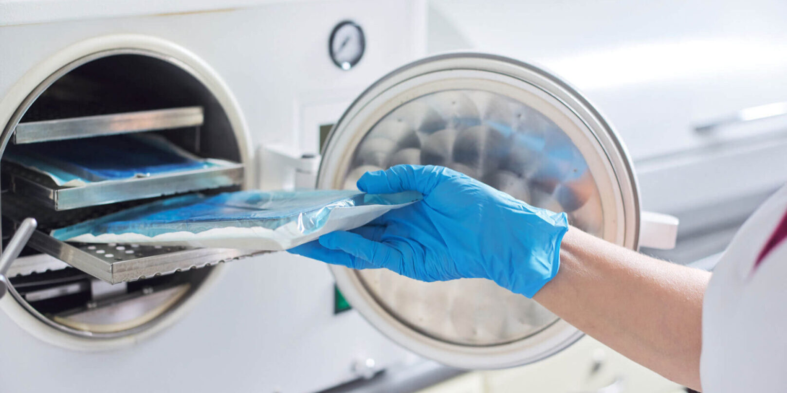 GettyImages-1202325953-copy A person wearing gloves and putting something in an oven.